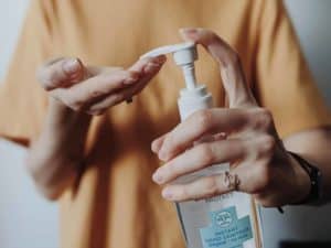 Woman pumping hand sanitizer from a bottle
